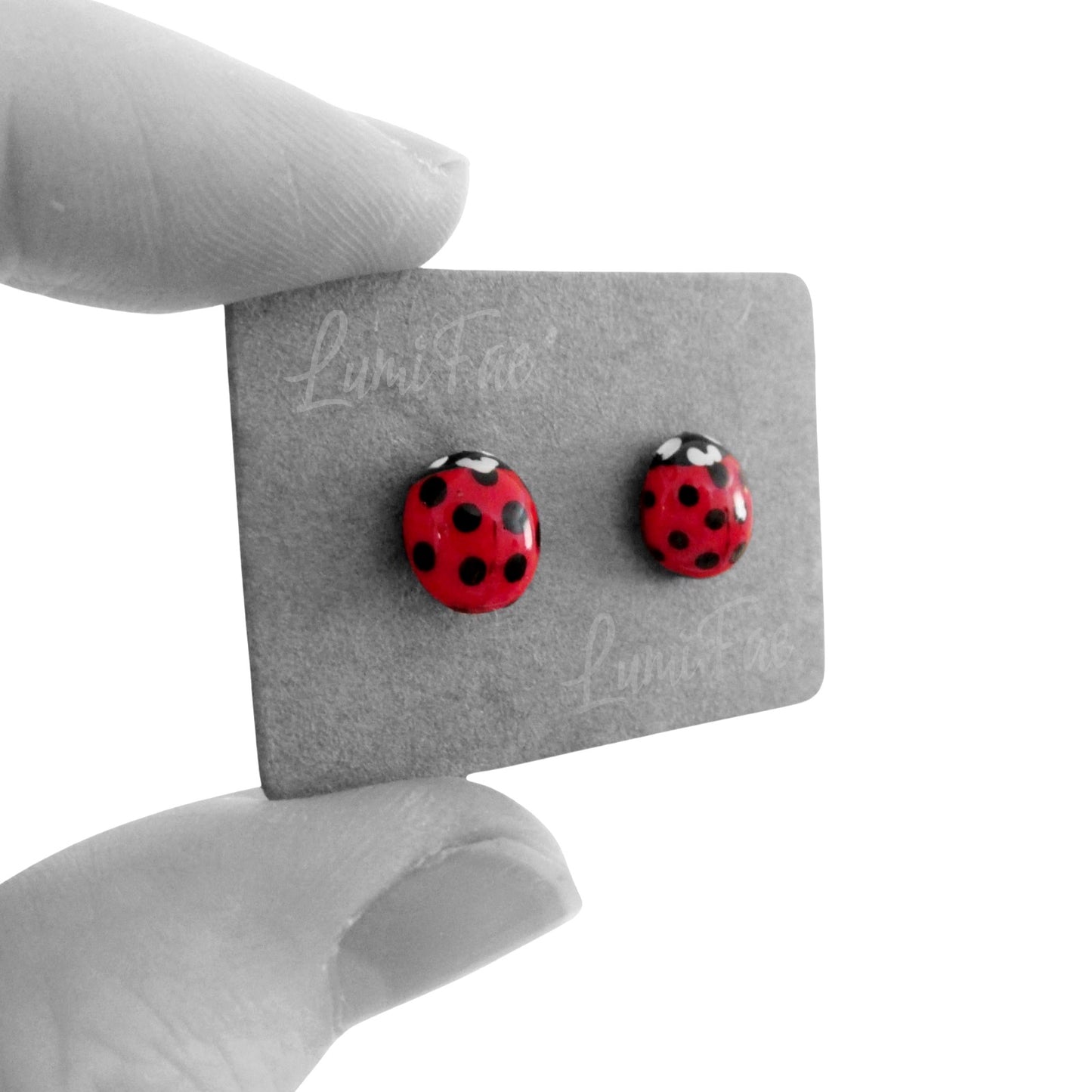 Close up of bright red glossy ladybug earrings on jewelry card